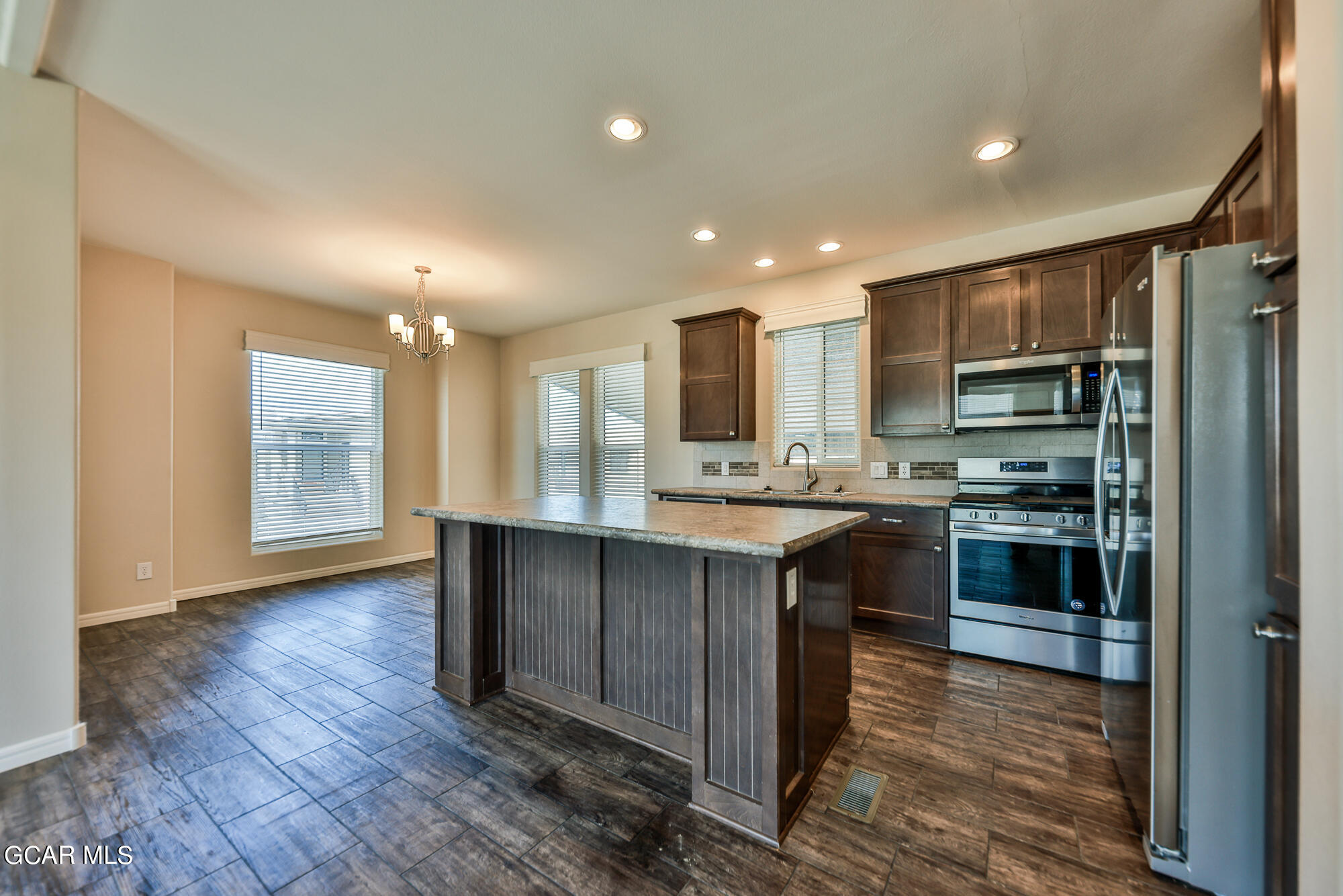 551 Summit Trail, Unit 145 Granby, CO 80446 - Photo 15 of 39 a kitchen with kitchen island granite countertop wooden floors stainless steel appliances a sink and a window