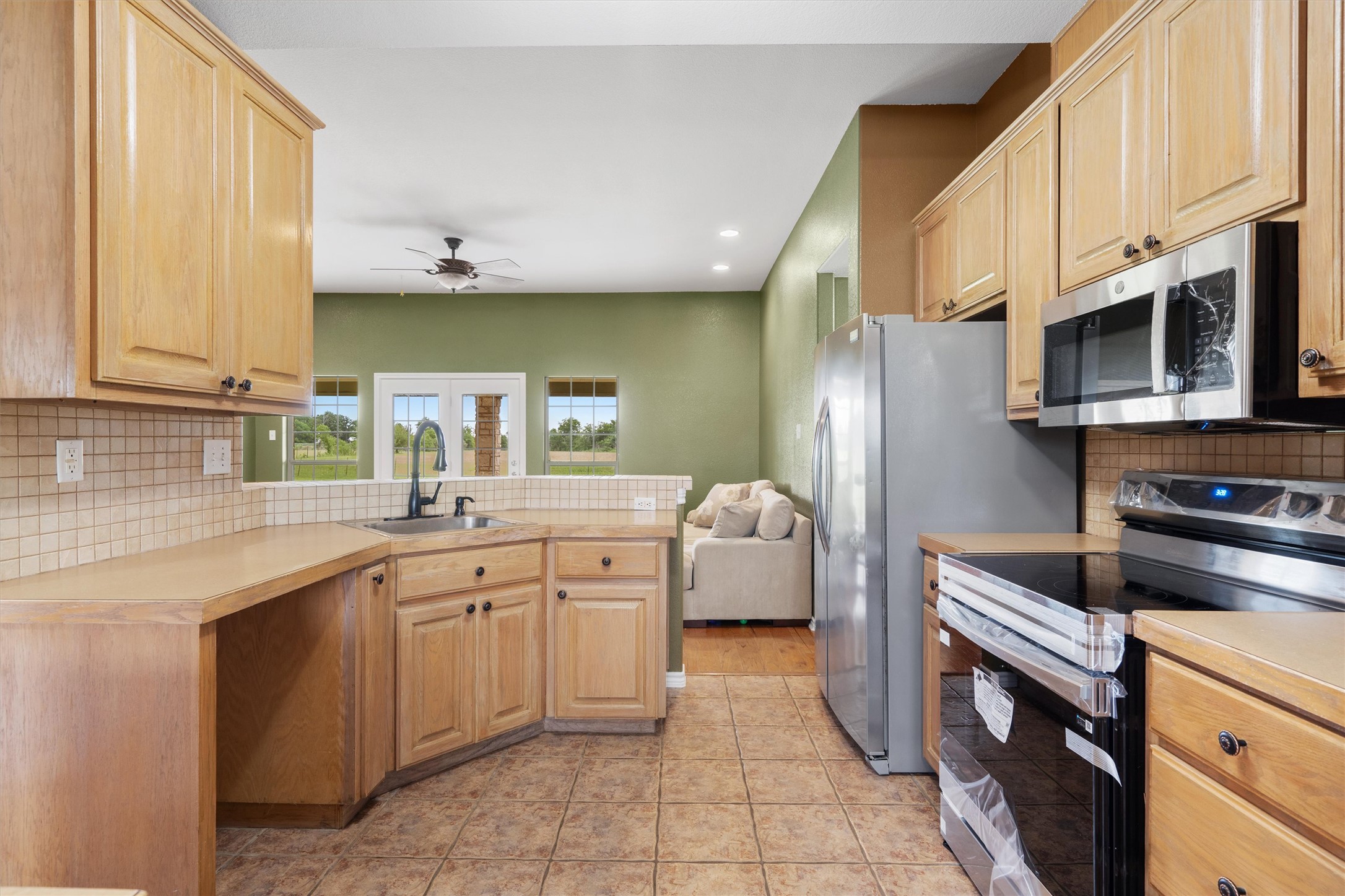 130 Cotton Rows Lane Taylor, TX 76574 - Photo 18 of 32 a kitchen with stainless steel appliances a sink dishwasher stove refrigerator and microwave