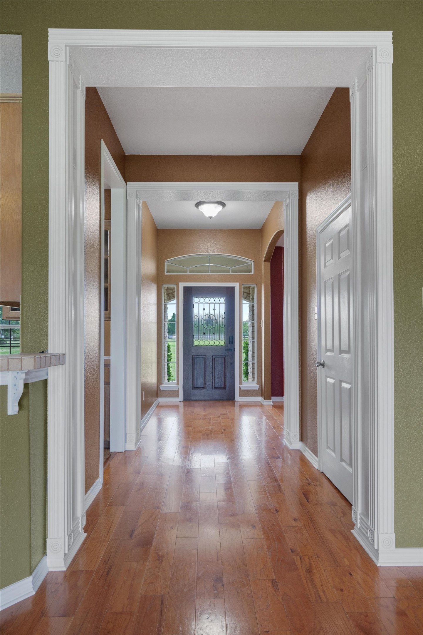 130 Cotton Rows Lane Taylor, TX 76574 - Photo 10 of 32 a view of a hallway with wooden floor and a living room