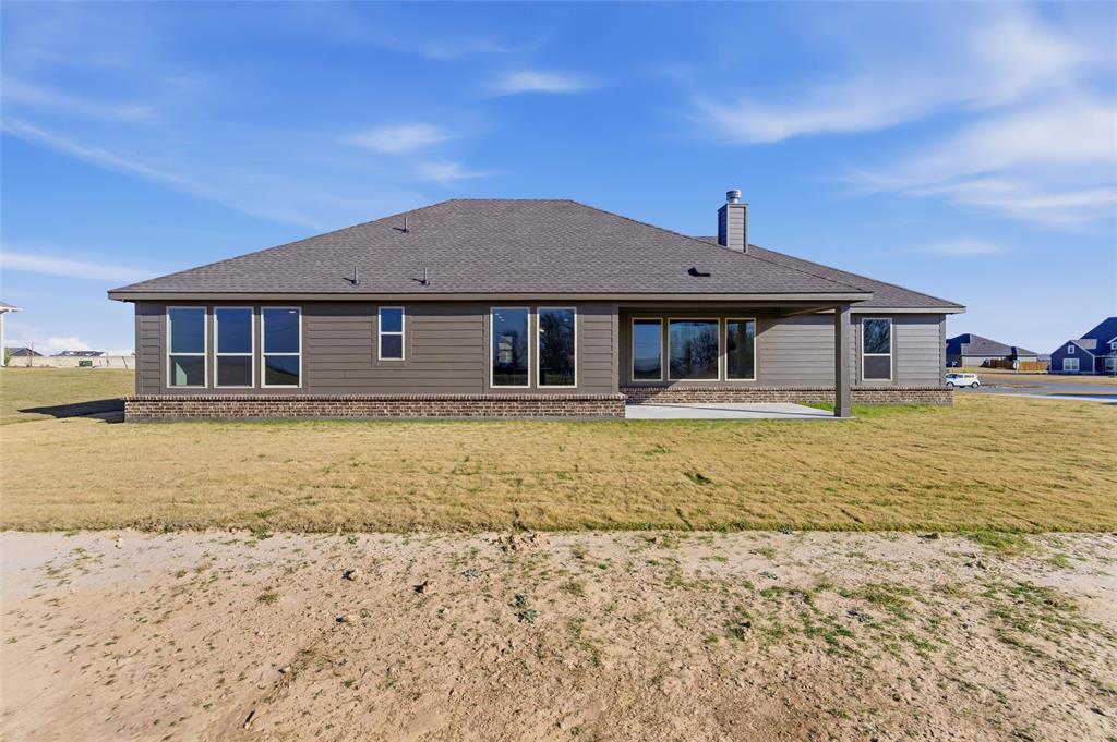 185 Brandywine Trail Rhome, TX 76078 - Photo 8 of 27 Back of property with a patio, brick siding, and a lawn