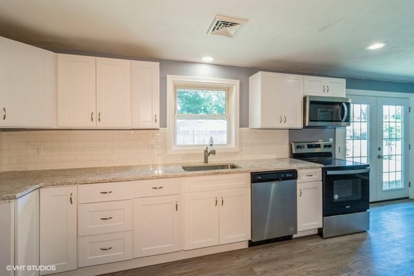 5 Dix Road Brockton, MA 02302 - Photo 7 of 15 a kitchen with white cabinets appliances a sink and a window