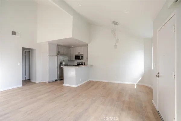 a view of an empty room with window and cabinet