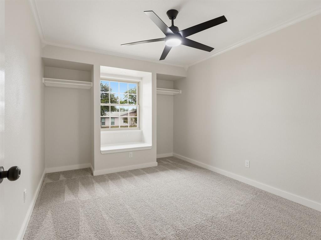 3109 Ridgedale Street Irving, TX 75062 - Photo 14 of 21 Unfurnished bedroom featuring light colored carpet, crown molding, a ceiling fan, and two closets