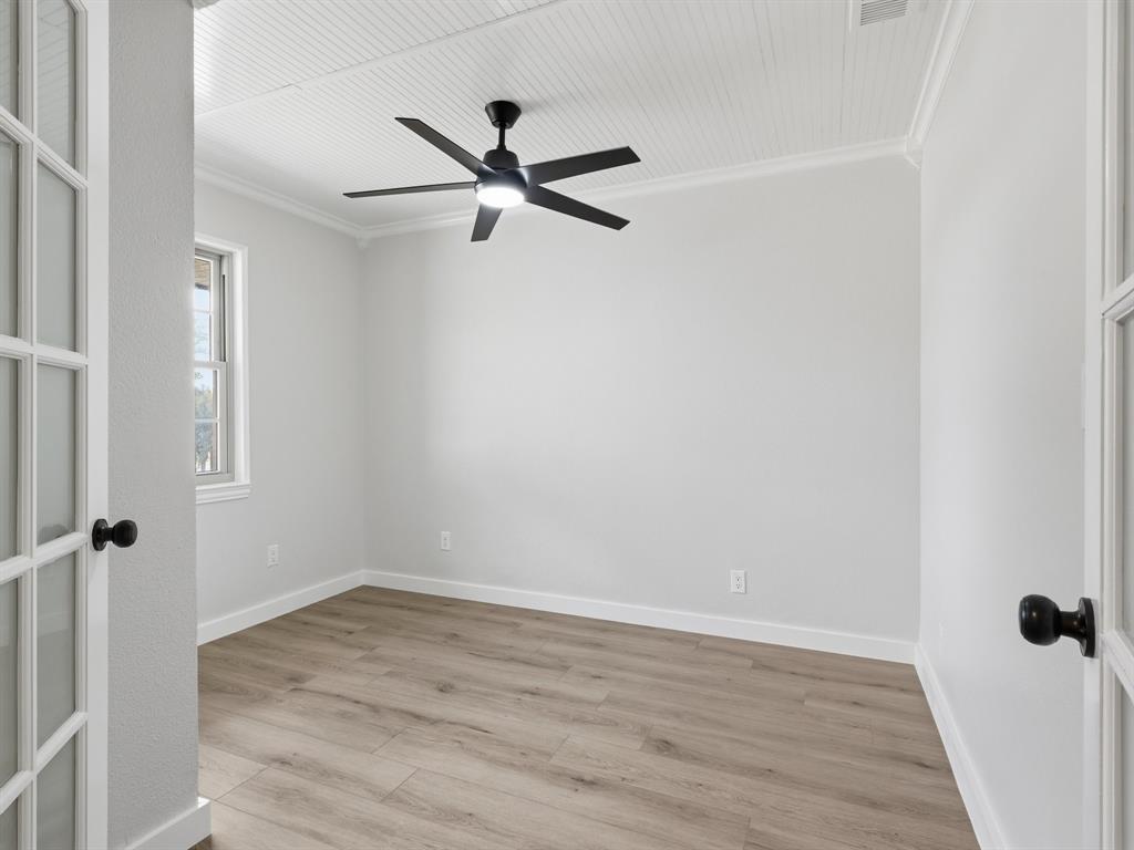 3109 Ridgedale Street Irving, TX 75062 - Photo 15 of 21 Unfurnished room featuring light wood finished floors, ornamental molding, and ceiling fan