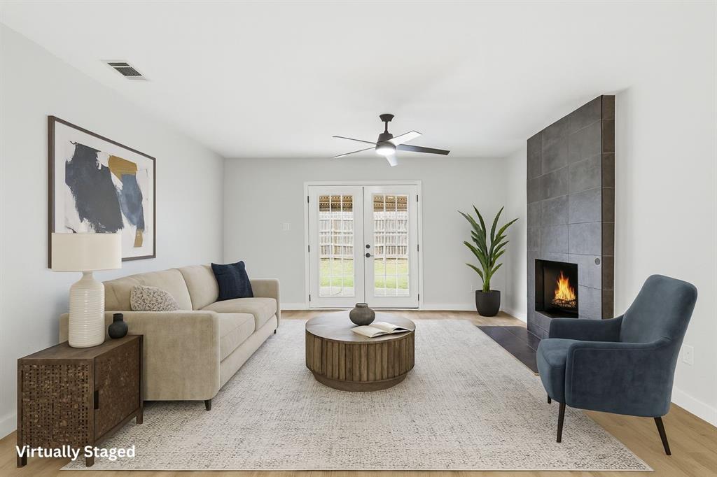 3109 Ridgedale Street Irving, TX 75062 - Photo 3 of 21 Living area with a fireplace, ceiling fan, light wood-style flooring, and french doors