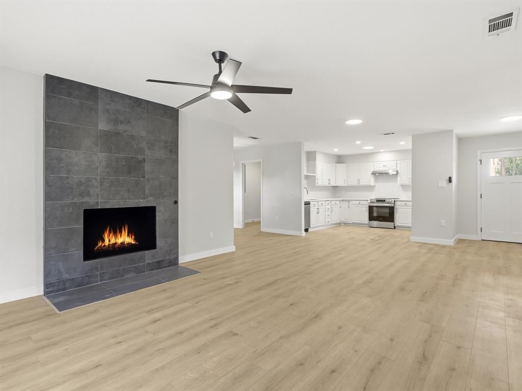 3109 Ridgedale Street Irving, TX 75062 - Photo 5 of 21 Unfurnished living room with a fireplace, light wood-style flooring, recessed lighting, and ceiling fan