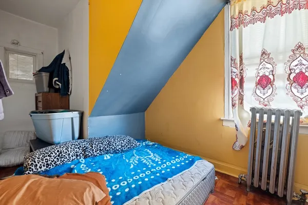 a bedroom with a bed and a painting on the wall