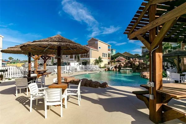a patio with a table and chairs under an umbrella