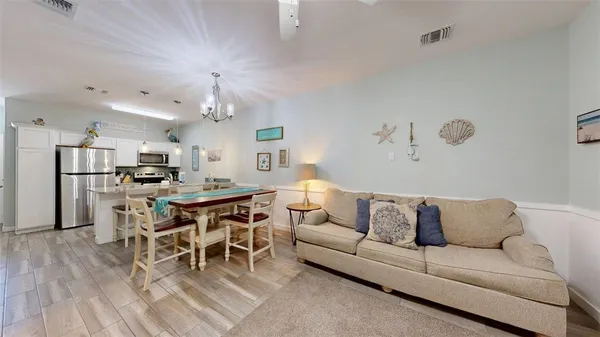 a living room with furniture a dining table and kitchen view