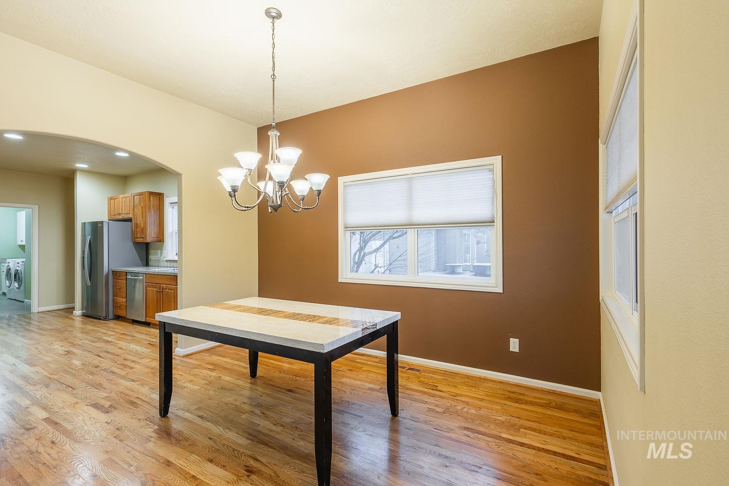 215 South Spring Lake Way Star, ID 83669 - Photo 11 of 50 Dining space with arched walkways, light wood-type flooring, a chandelier, separate washer and dryer, and recessed lighting