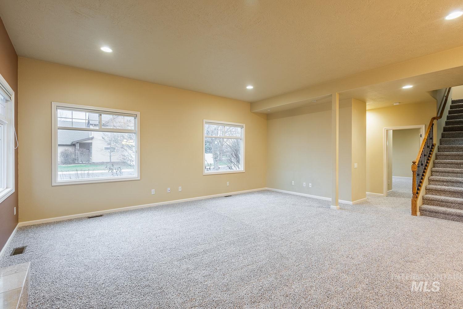 215 South Spring Lake Way Star, ID 83669 - Photo 6 of 50 Unfurnished room with stairs, light colored carpet, recessed lighting, and a textured ceiling