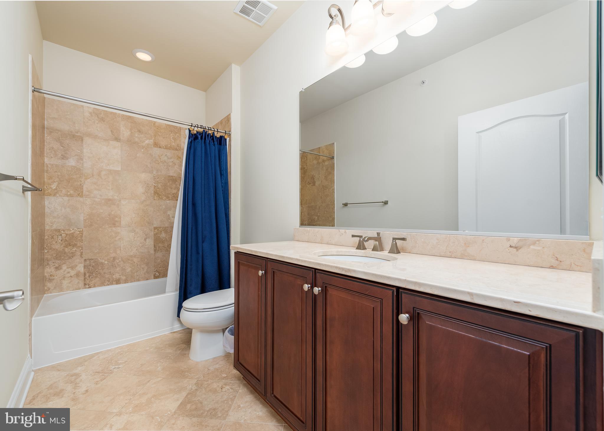 7662 Maple Lawn Boulevard, Unit 26 Fulton, MD 20759 - Photo 17 of 37 a bathroom with a granite countertop sink a toilet a mirror a bathtub and shower