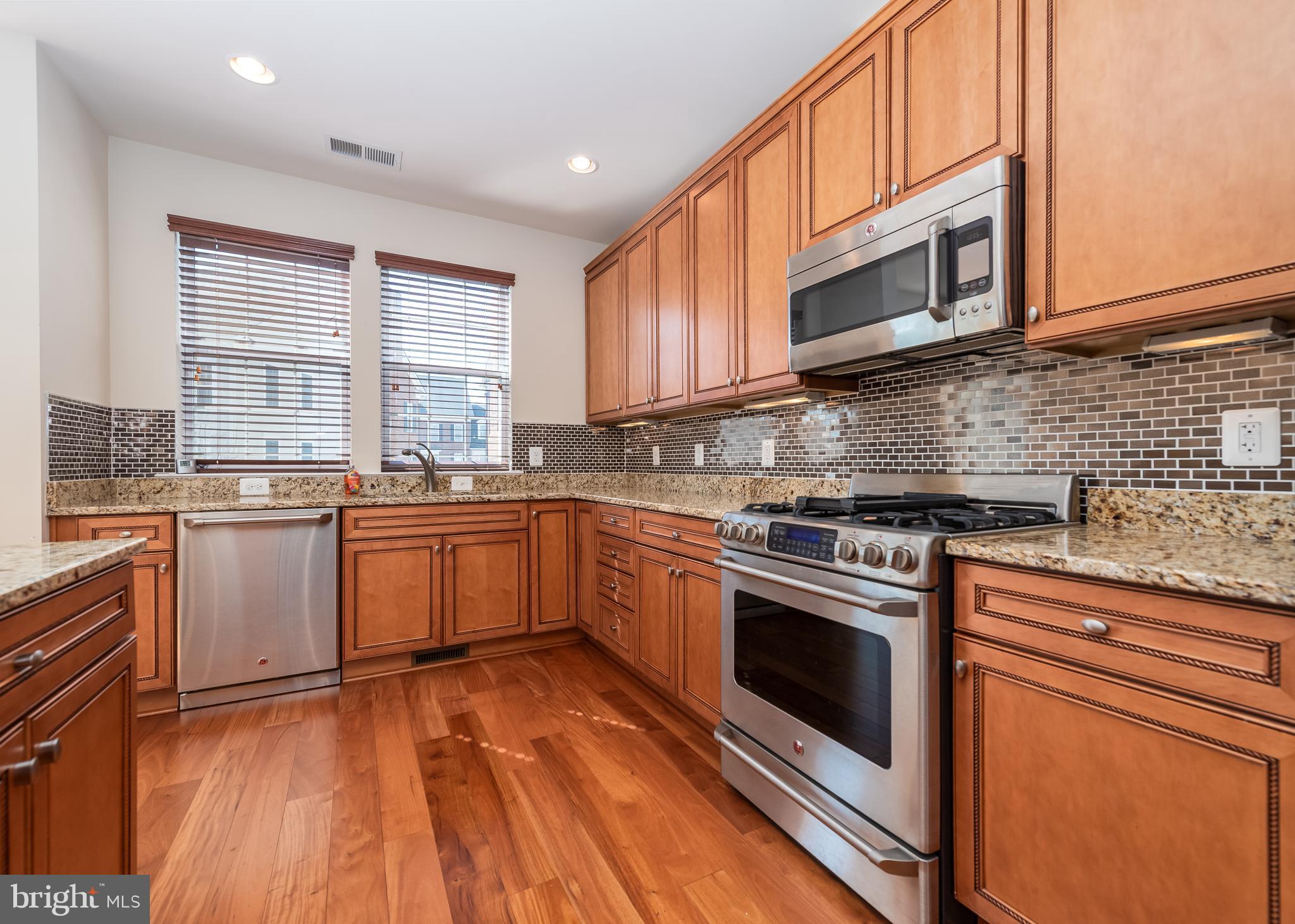 7662 Maple Lawn Boulevard, Unit 26 Fulton, MD 20759 - Photo 3 of 37 a kitchen with stainless steel appliances granite countertop a stove a sink and a microwave