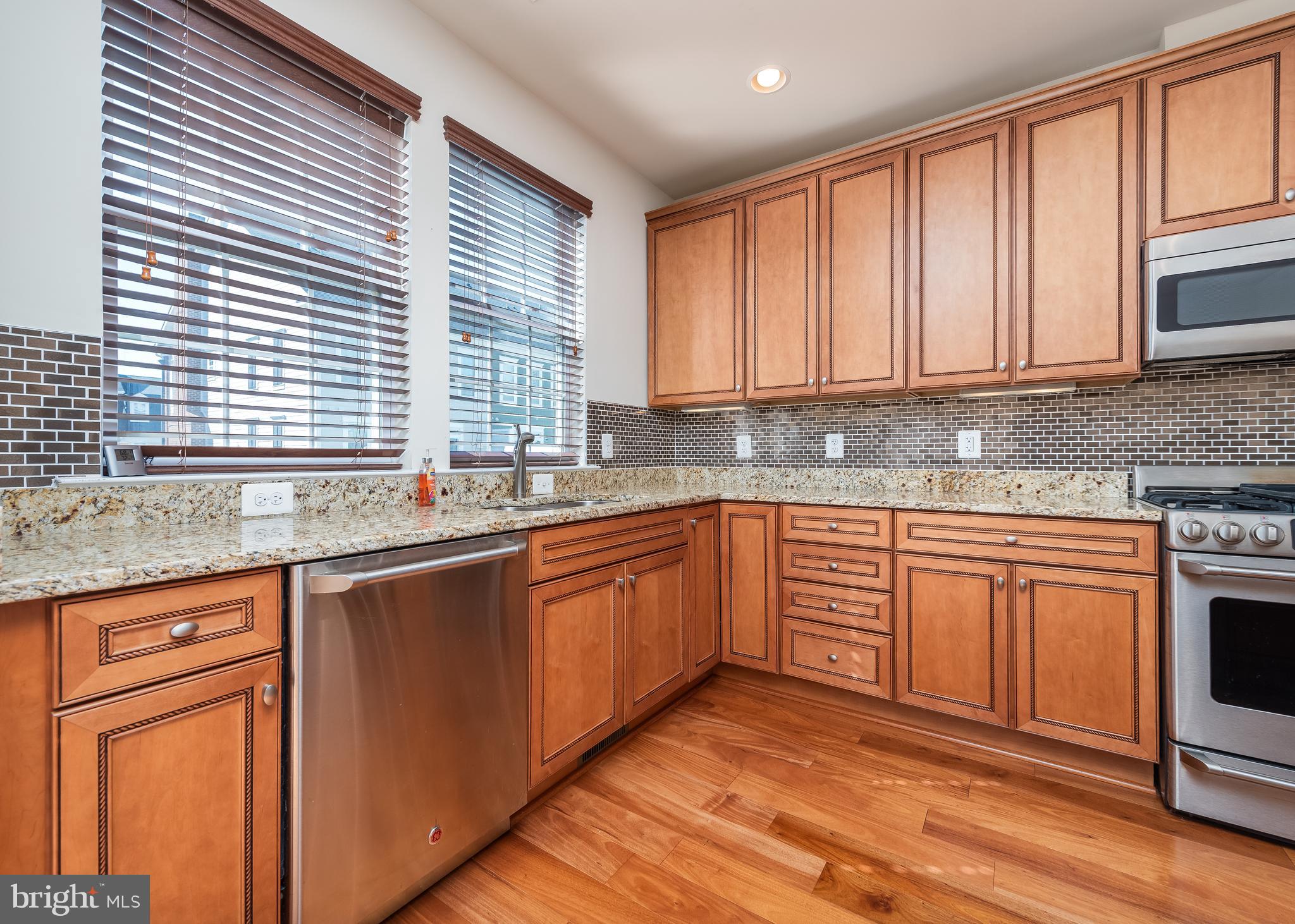 7662 Maple Lawn Boulevard, Unit 26 Fulton, MD 20759 - Photo 5 of 37 a kitchen with stainless steel appliances granite countertop a stove a sink and a microwave