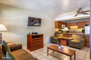 5829 East Buck Springs Road, Unit 140 Pinetop, AZ 85935 - Photo 20 of 37 a living room with furniture a flat screen tv and kitchen view