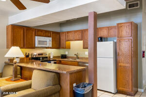 5829 East Buck Springs Road, Unit 140 Pinetop, AZ 85935 - Photo 24 of 37 a kitchen with stainless steel appliances a refrigerator sink and cabinets