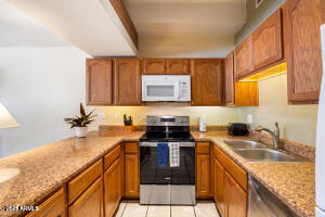 5829 East Buck Springs Road, Unit 140 Pinetop, AZ 85935 - Photo 25 of 37 a kitchen with a sink a stove and cabinets