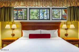 a room with a bed and large windows