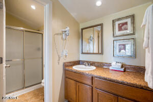 5829 East Buck Springs Road, Unit 140 Pinetop, AZ 85935 - Photo 34 of 37 a bathroom with a granite countertop sink mirror and shower