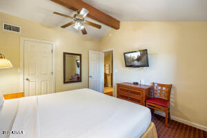 5829 East Buck Springs Road, Unit 140 Pinetop, AZ 85935 - Photo 36 of 37 a bedroom with a bed and a flat screen tv