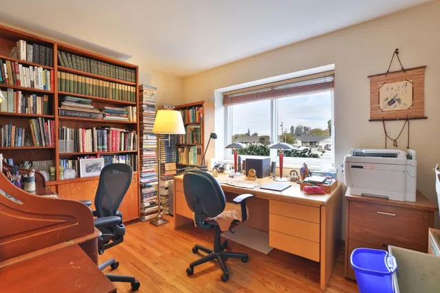 a view of a workspace with furniture and a window