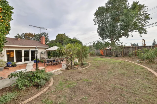 a view of a backyard with table and chairs under an umbrella