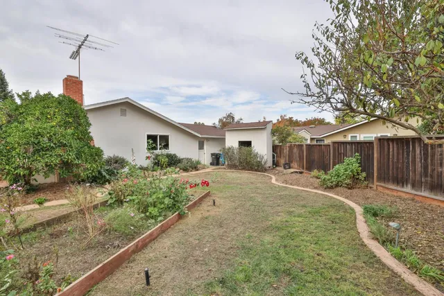 a front view of a house with a yard and potted plants