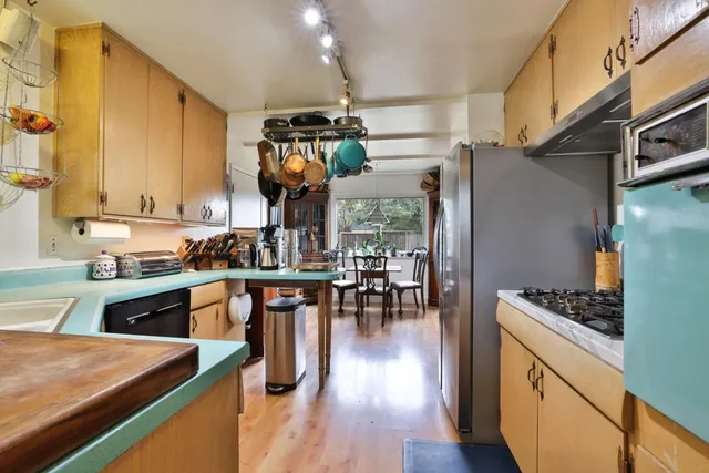 a kitchen with stainless steel appliances kitchen island granite countertop a stove a sink and a refrigerator