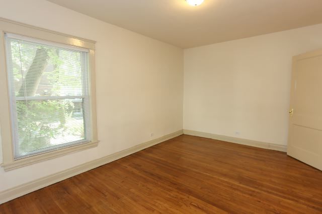 4716 North Racine Avenue, Unit 2E Chicago, IL 60640 - Photo 14 of 19 a view of an empty room with wooden floor and a window