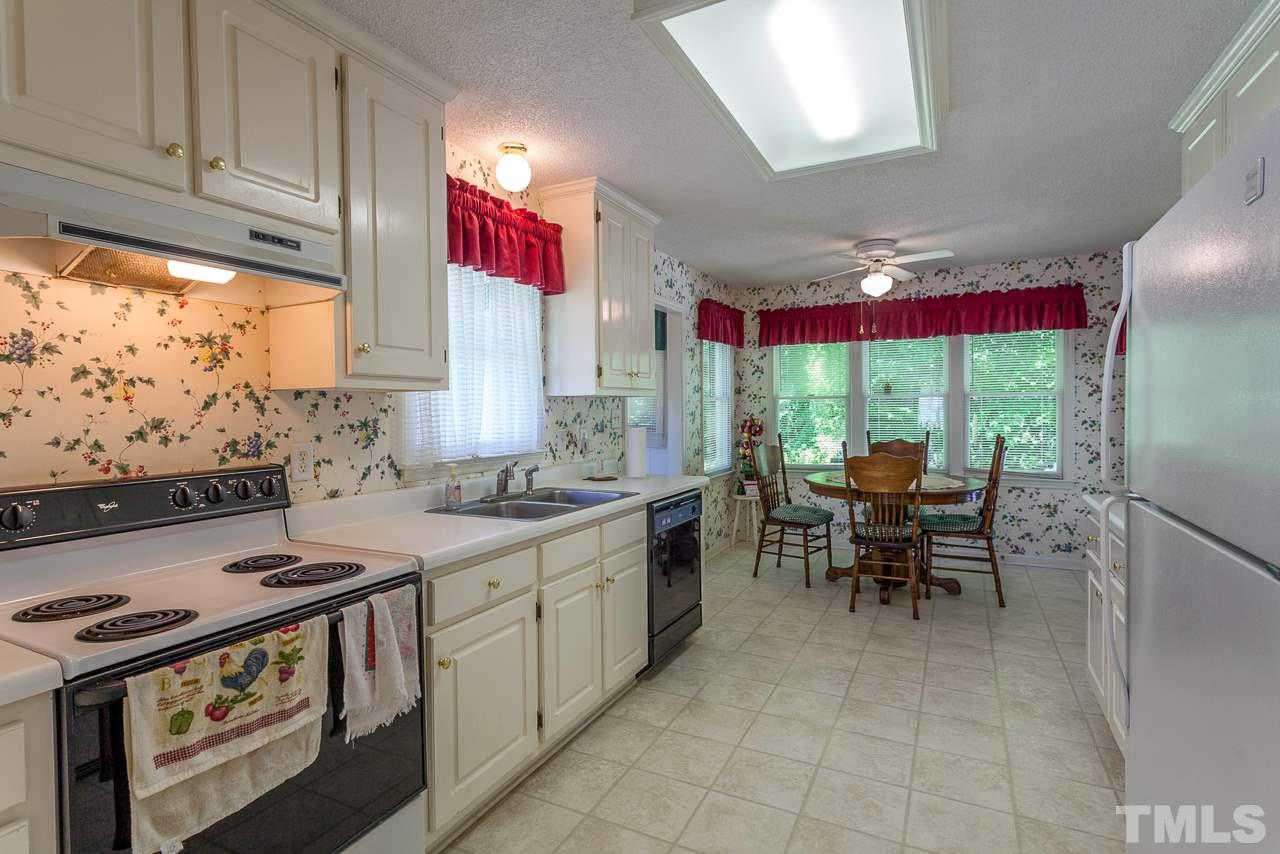 5110 Raleigh Road Benson, NC 27504 - Photo 4 of 24 a kitchen with stainless steel appliances granite countertop a stove a sink and a microwave