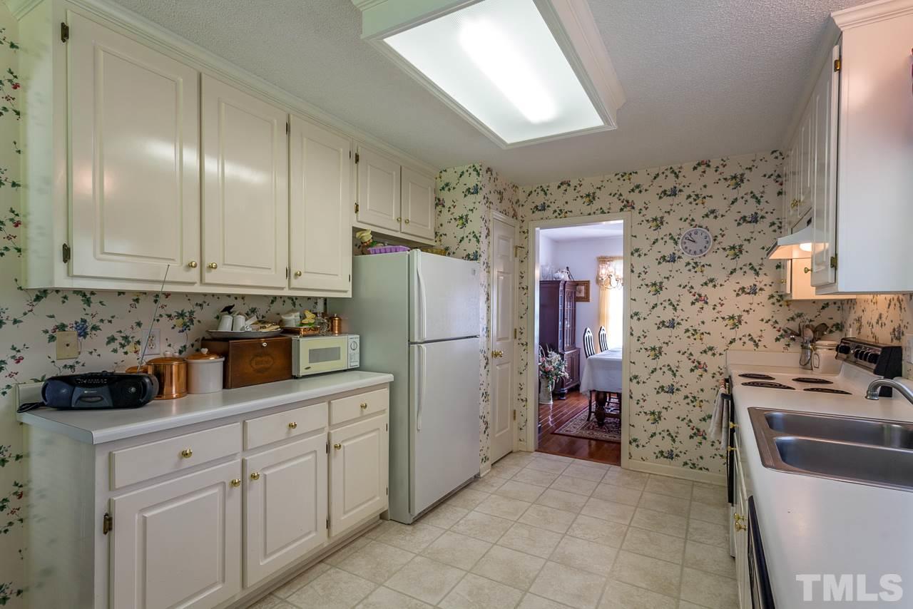 5110 Raleigh Road Benson, NC 27504 - Photo 6 of 24 a kitchen with a sink refrigerator and cabinets