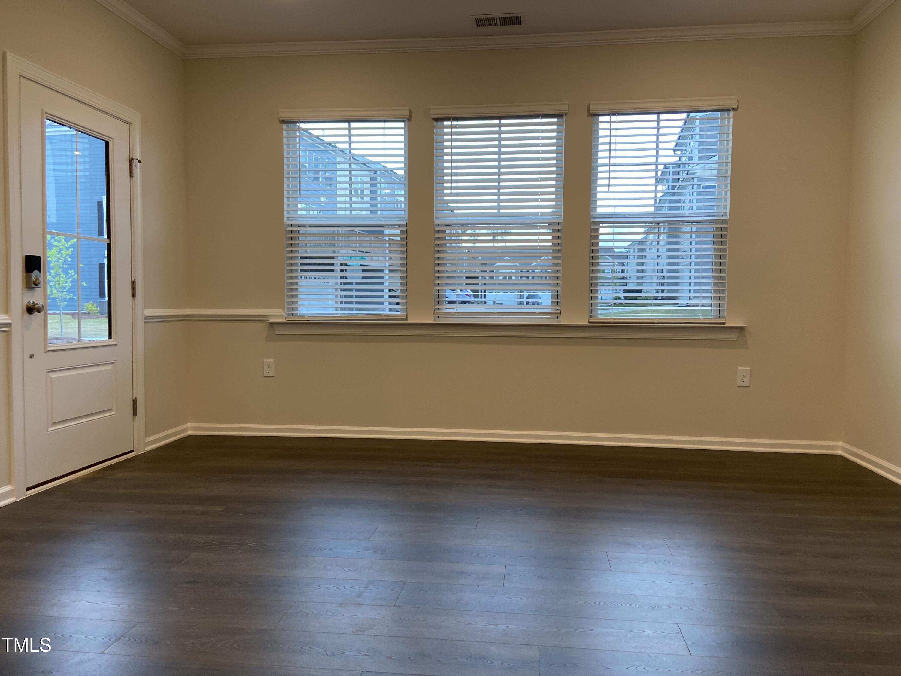 856 Patriot Summit Lane Apex, NC 27523 - Photo 2 of 25 an empty room with wooden floor and windows