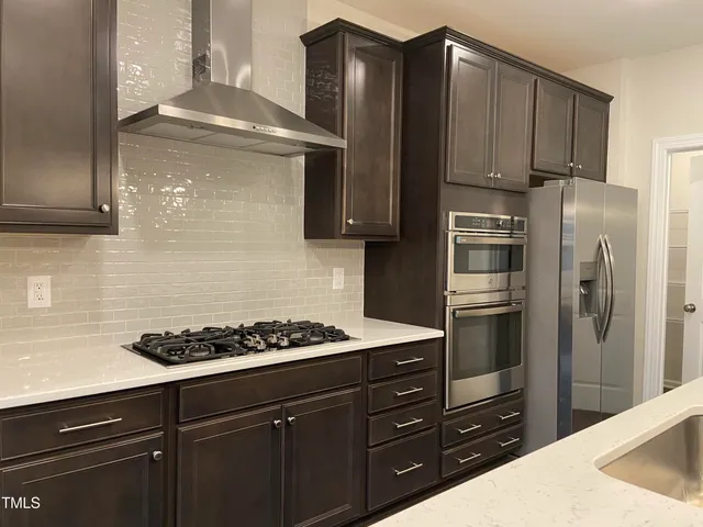a kitchen with a refrigerator a stove and cabinets
