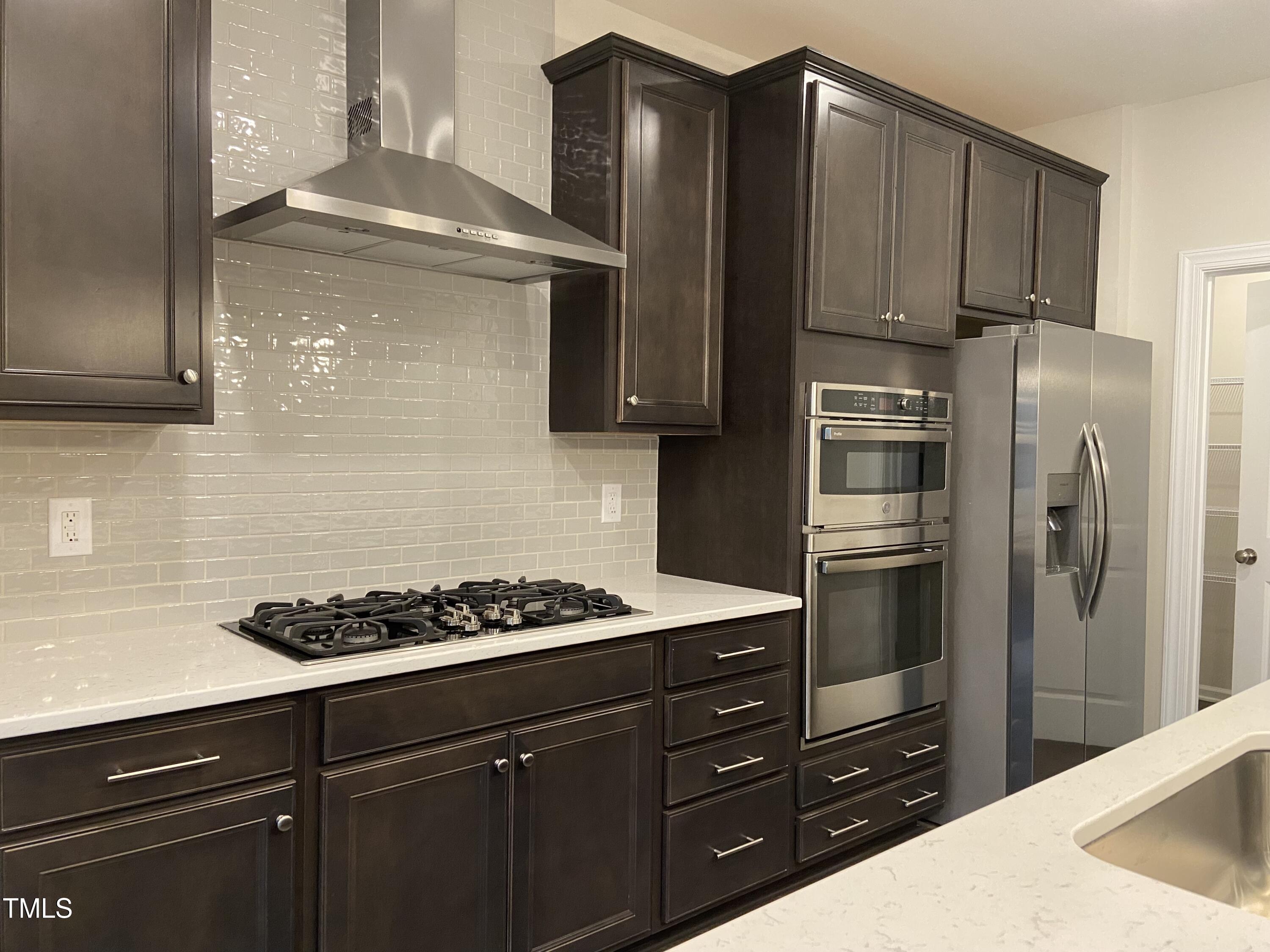856 Patriot Summit Lane Apex, NC 27523 - Photo 5 of 25 a kitchen with a refrigerator a stove and cabinets