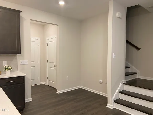 a view of a hallway with wooden floor and bathroom