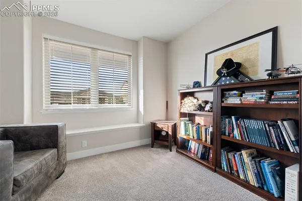 a living room with baby crib and a book shelf
