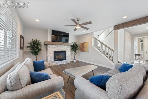 a living room with furniture a flat screen tv and a fireplace