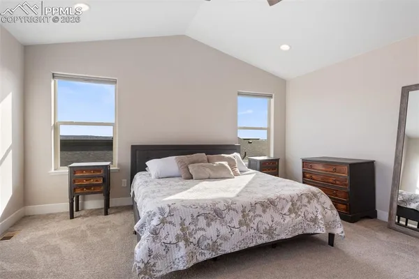 a spacious bedroom with a bed and a television