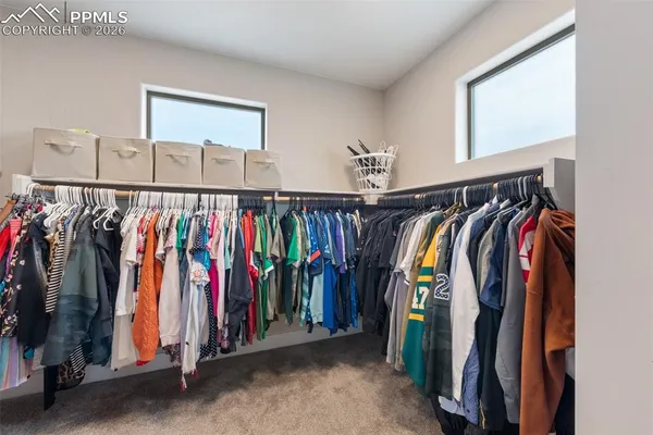 a view of walk in closet with clothes