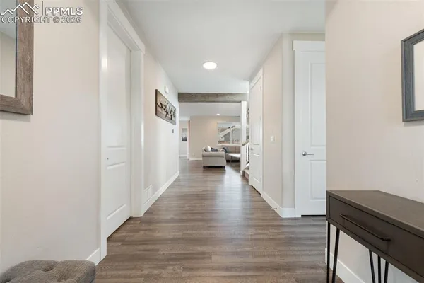 a view of a hallway with wooden floor windows and a livingroom