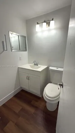 a bathroom with a toilet sink and mirror