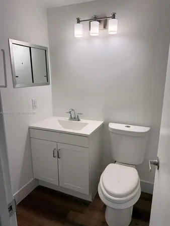a bathroom with a sink mirror and toilet