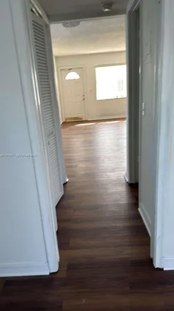 a view of hallway with stairs and wooden floor