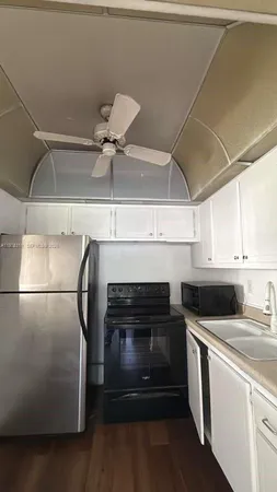 a kitchen with a refrigerator and white cabinets