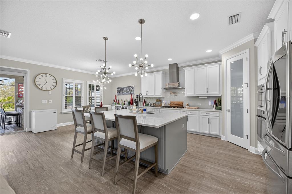 7424 Paradiso Drive Apollo Beach, FL 33572 - Photo 39 of 99 a kitchen with kitchen island a dining table chairs stainless steel appliances and cabinets