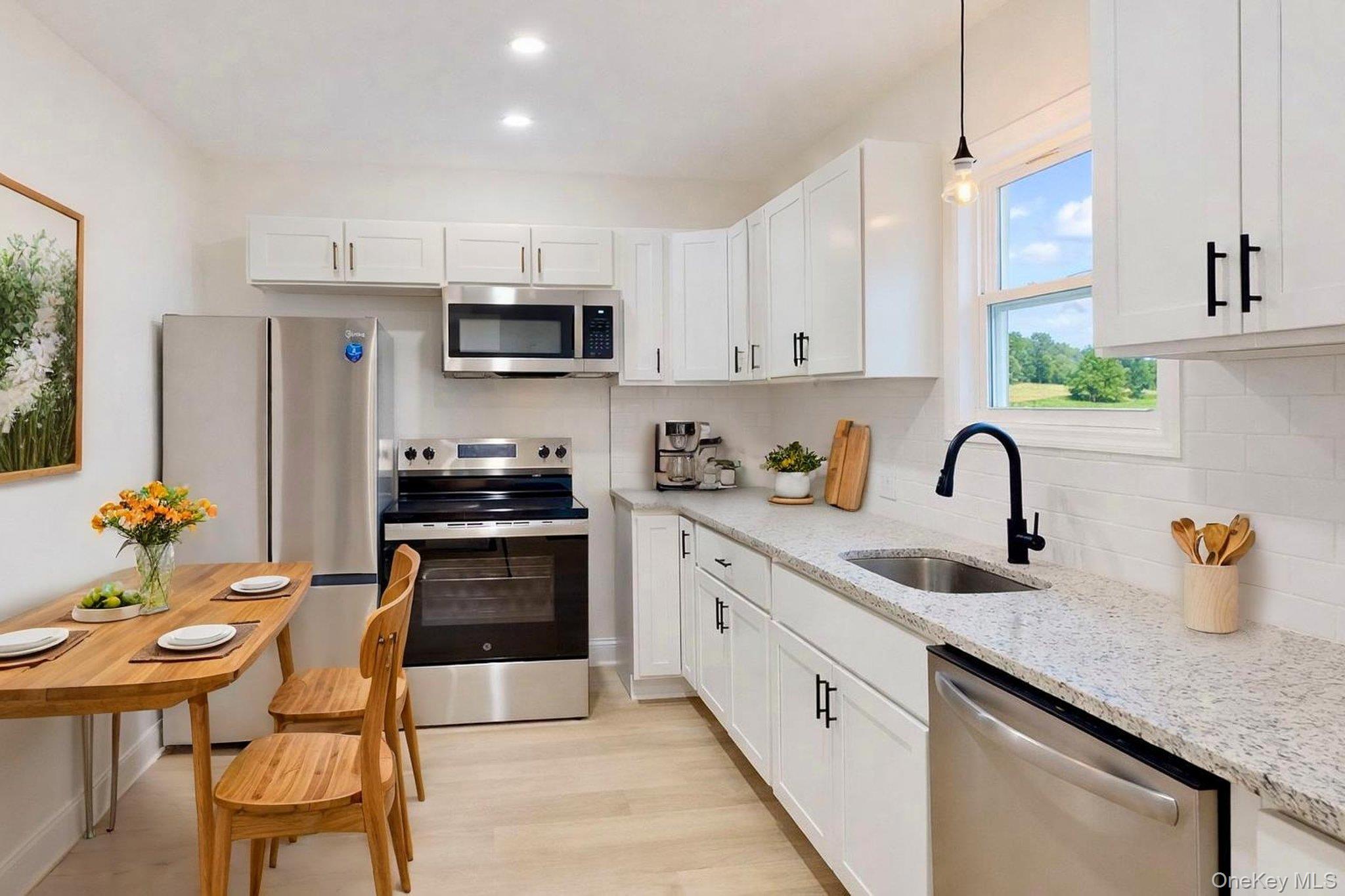 548 Dosen Road Middletown, NY 10940 - Photo 15 of 41 Kitchen with stainless steel appliances, white cabinets, light stone counters, and light wood-type flooring