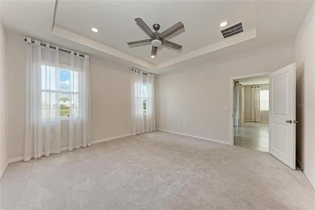 an empty room with a chandelier fan and a bathroom
