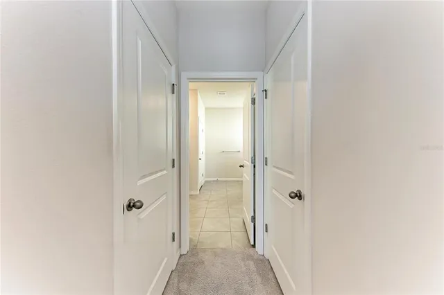 an empty room with a chandelier fan and closet area