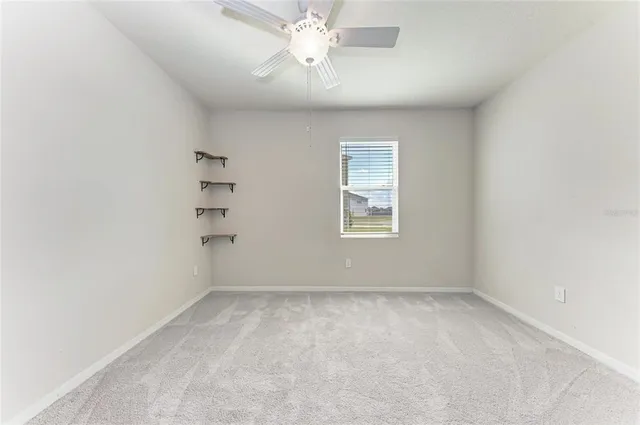 an aerial view of a house with a yard and a large tree