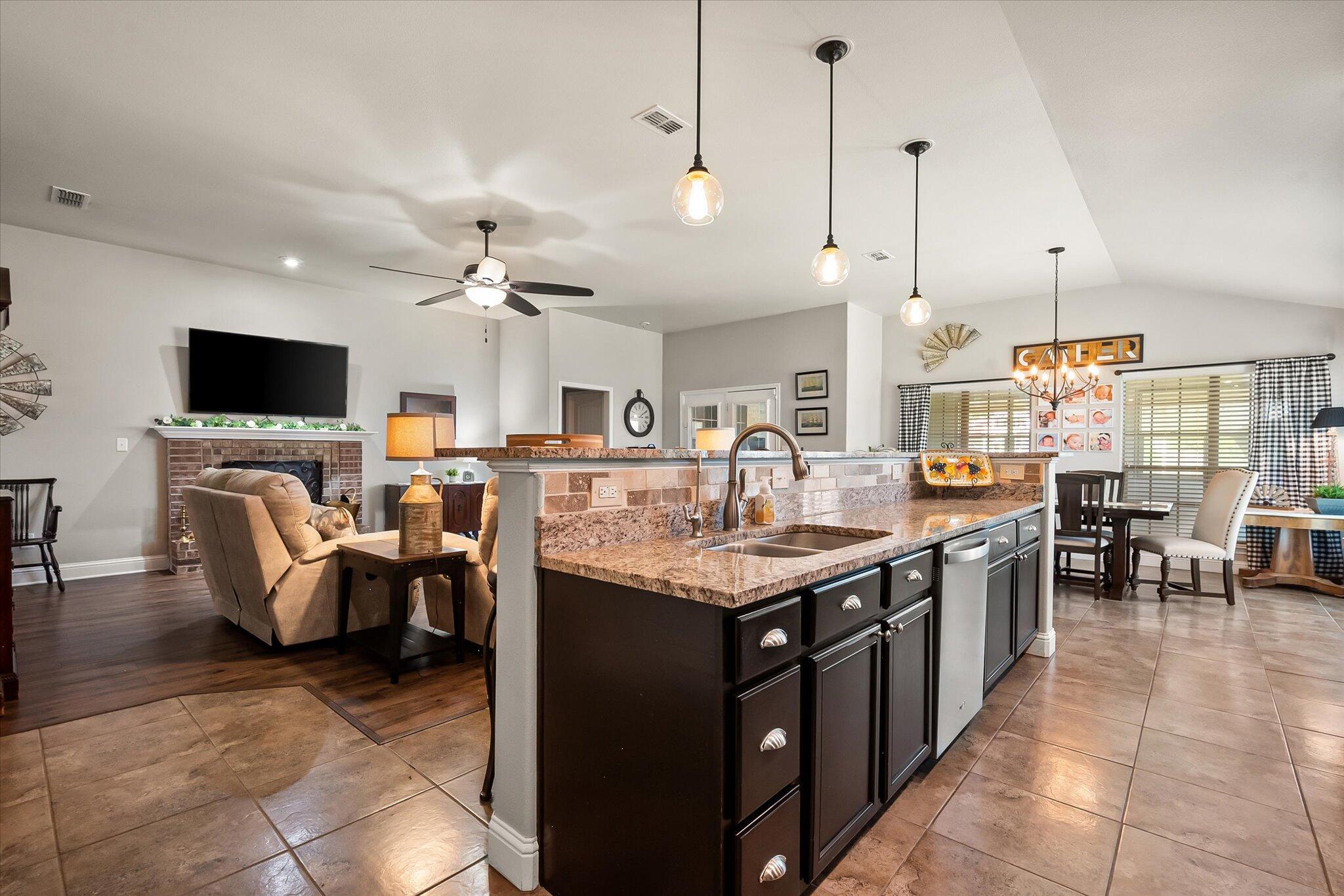 3106 128th Street Lubbock, TX 79423 - Photo 12 of 44 a open kitchen with stainless steel appliances granite countertop a stove top oven a dining table and chairs